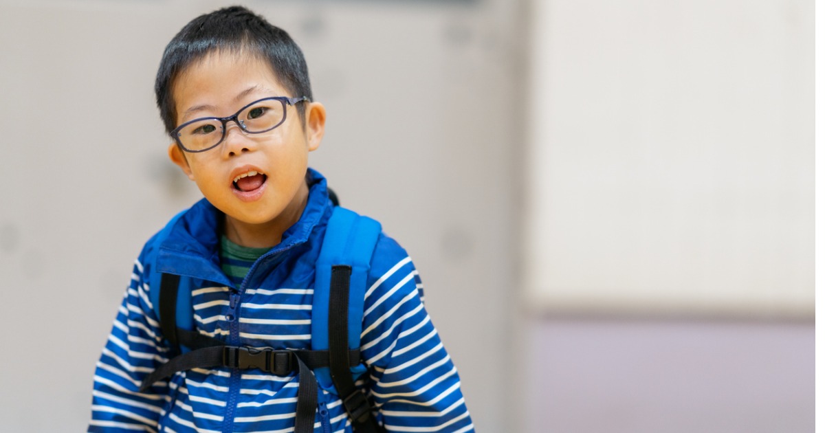 A young boy wearing a backpack