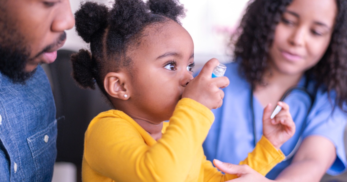 A young girl uses an inhaler