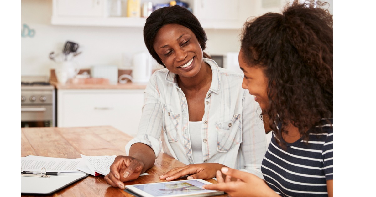 A mother and daughter look at a tablet