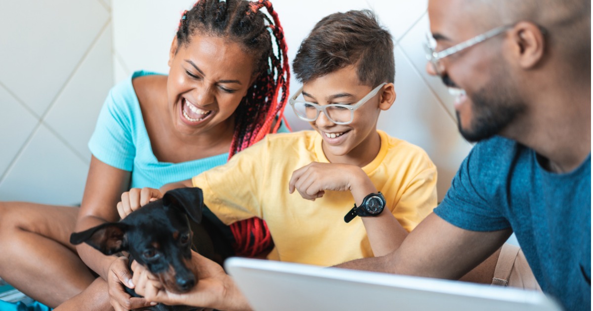 A family plays with their dog