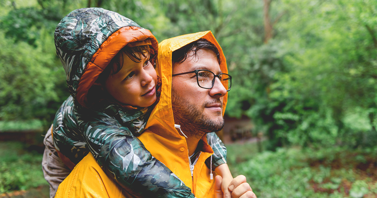 A father and son outside in the rain