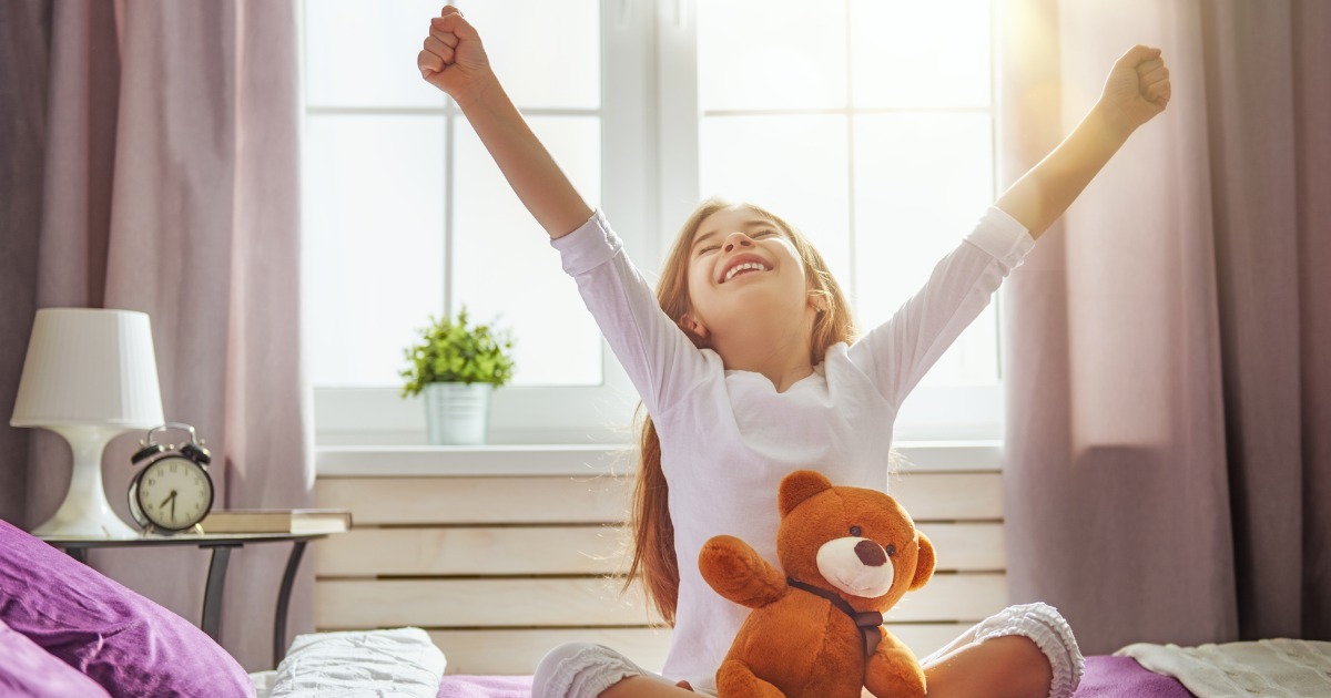 Young girl wakes up and stretches