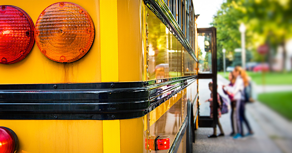 Kids getting on a school bus