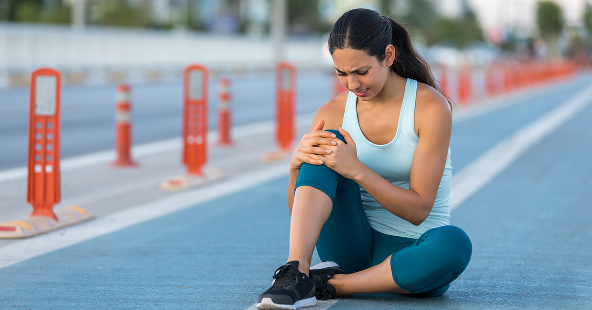 woman holding her knee in pain