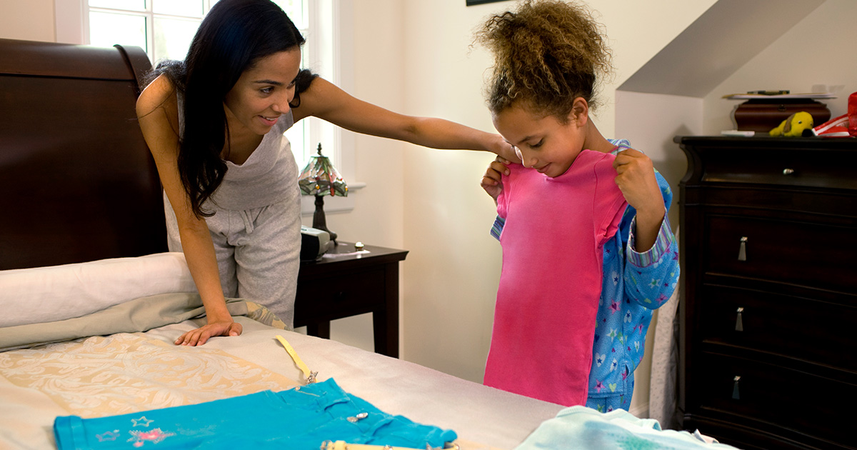 Mother helping her daughter pick out clothes