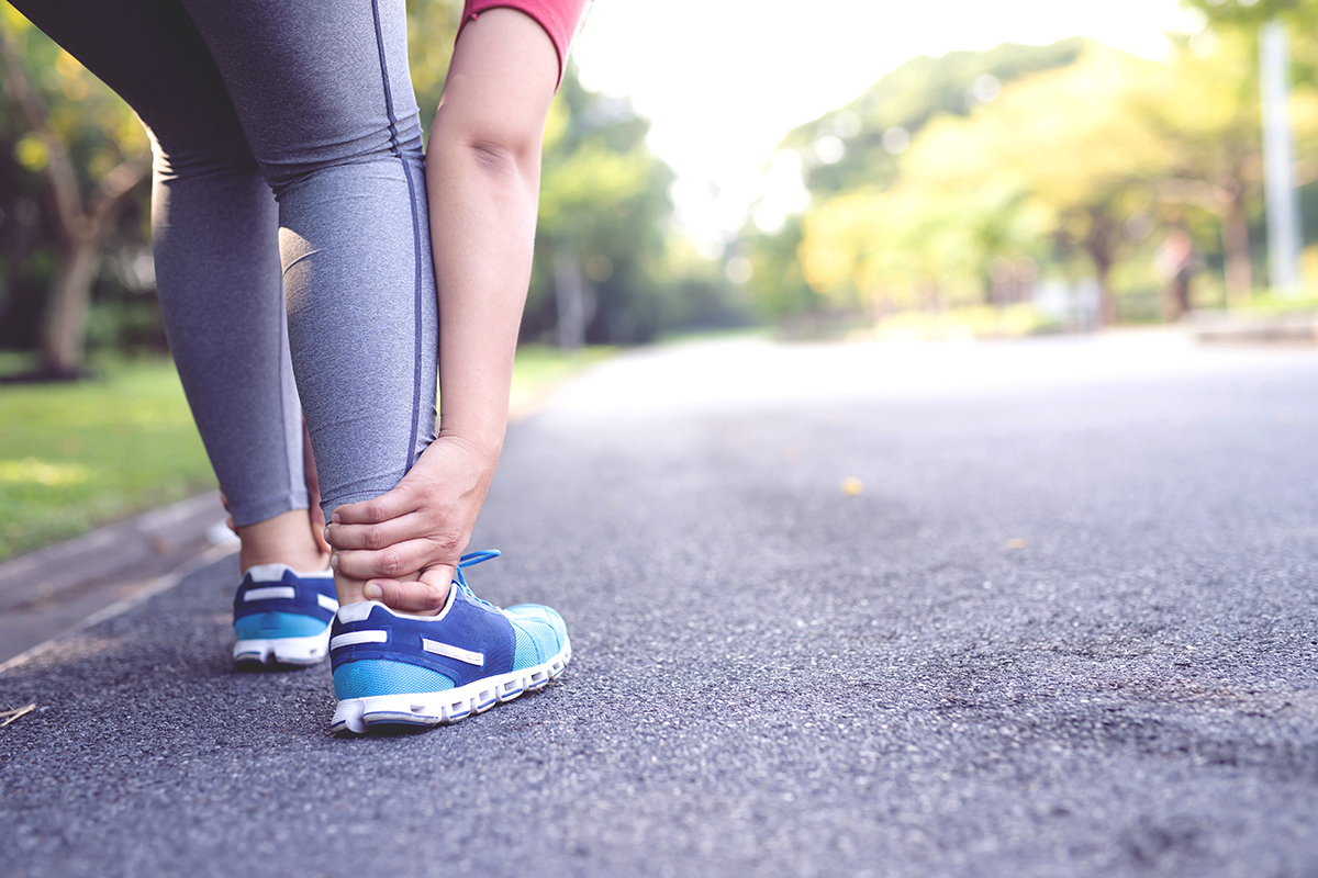 woman holding her ankle in pain