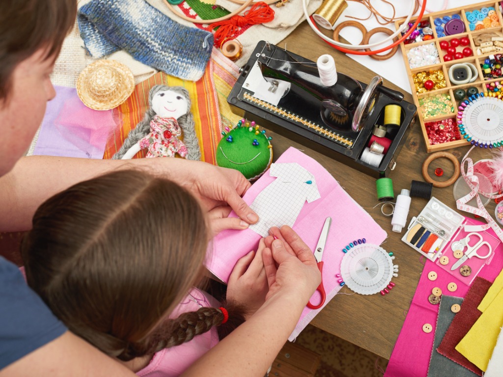 Top-down view of mother and daughter working on a craft project