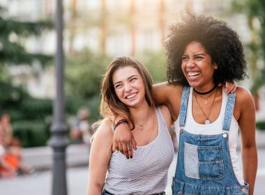 Teenage females smiling, in street. Motivate your teen this summer.