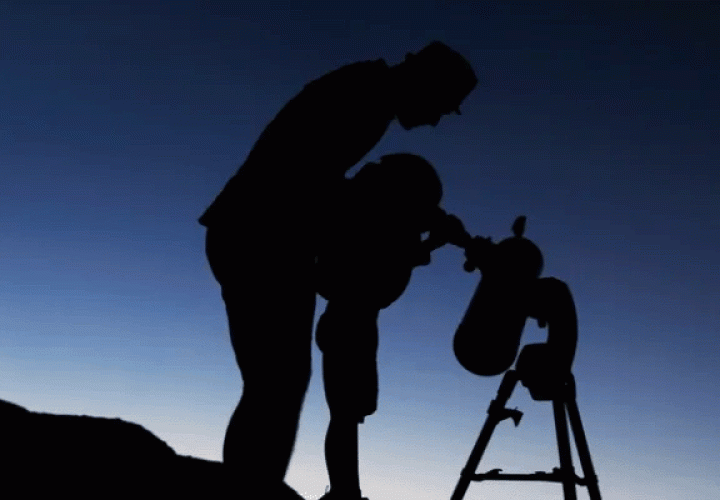 Dad and child looking through a telescope