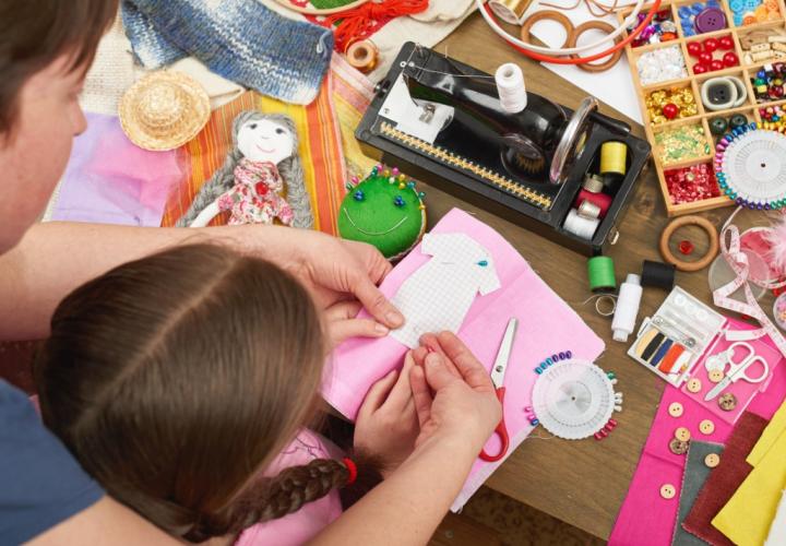 Top-down view of mother and daughter working on a craft project