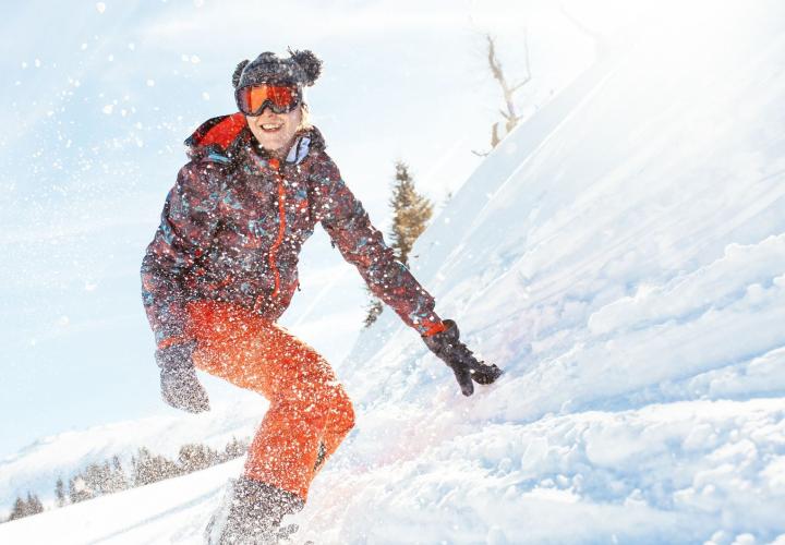 Female snowboarder on slopes, 8 injury prevention tips for skiing and snowboarding