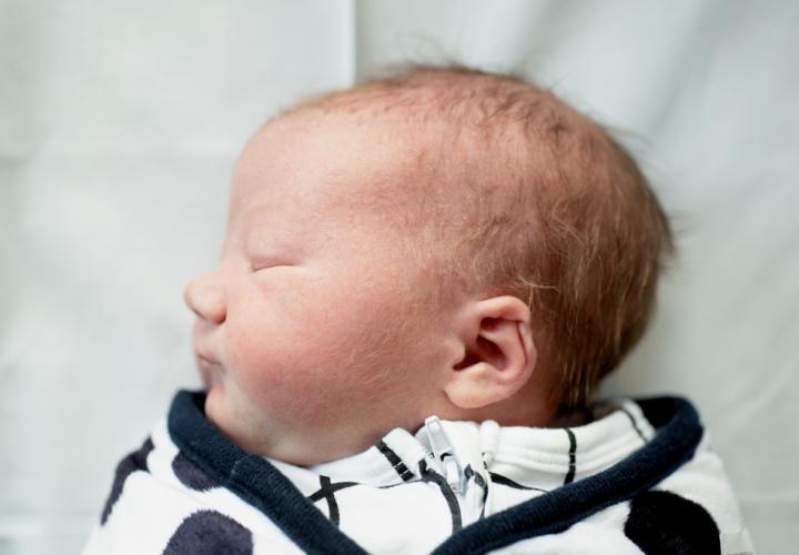 Newborn baby boy sleeping, profile view, ear folded inward