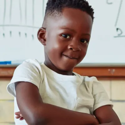 Boy crossing his arms in front of a whiteboard