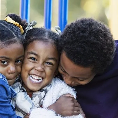 family hugging on a playscape