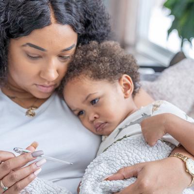 A mother checks her toddlers temperature