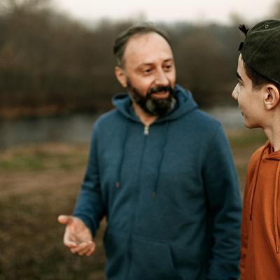 A dad talking with his son outside