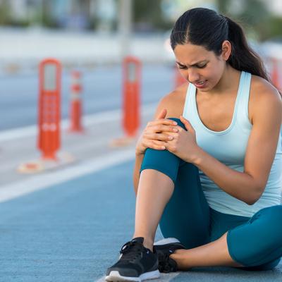 woman holding her knee in pain