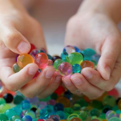 Water beads in hand over bowl. Dangerous toy.