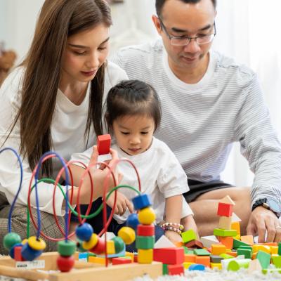 Parents building blocks with child. 