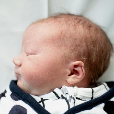 Newborn baby boy sleeping, profile view, ear folded inward