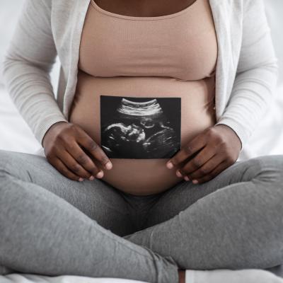 Black Woman holding sonogram. 