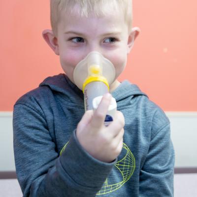 Child taking inhaler. 