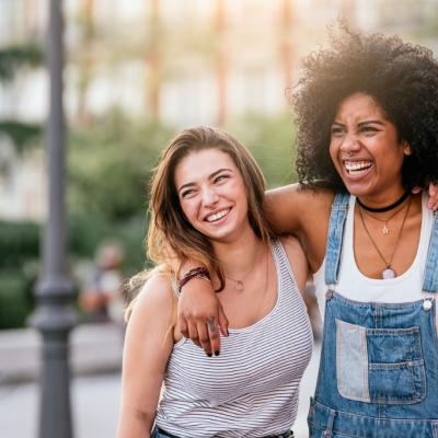 Teenage females smiling, in street. Motivate your teen this summer.